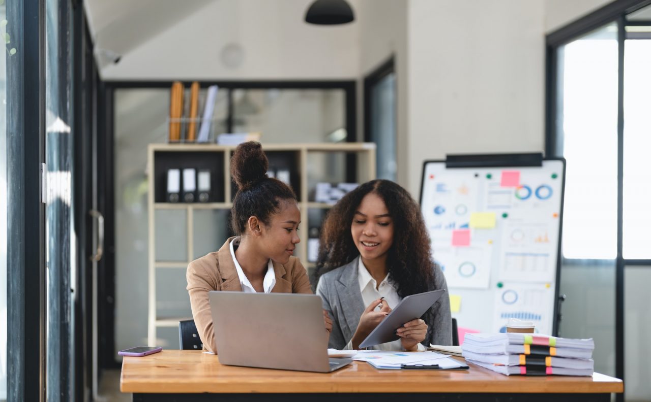 two-young-business-people-working-together-in-office-financial-analysis-accounting-concept